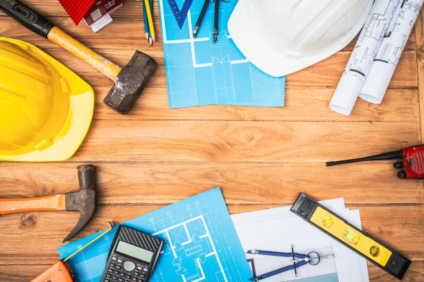istock Top view desk of Engineer tools meticulously designs structures at desk, referring to blueprints for precision. Focuses on innovation, problem-solving, and attention to detail in engineering projects 2151063673