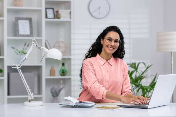 istock Hispanic businesswoman smiling in home office setting 2151064356