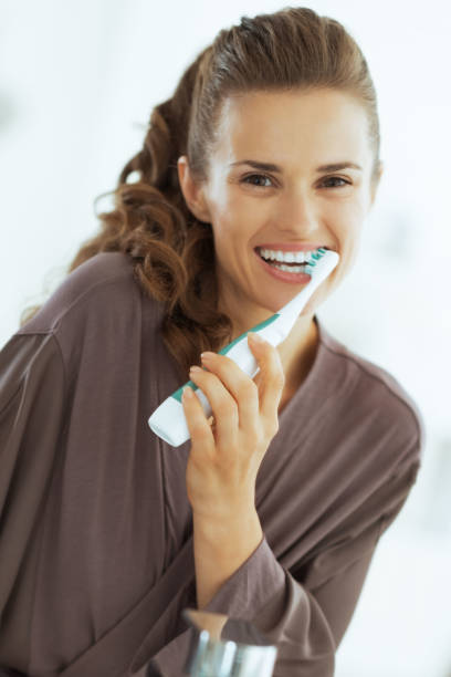 istock Happy young woman brushing teeth in bathroom 2151066523