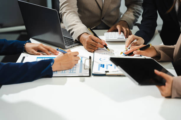 istock Business, technology and office concept - business team with laptop, tablet pc computer and papers having discussion in modern office. 2151069298