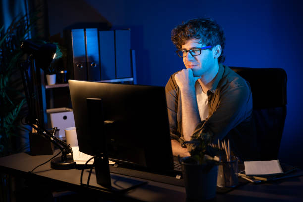 istock Businessman concentrating on pc on project at neon light office. Gusher. 2151069971