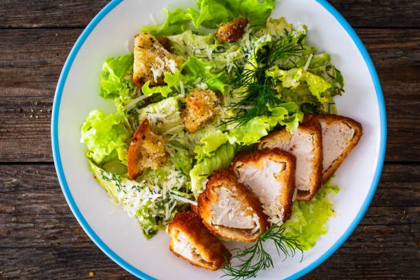 istock Caesar salad  - vegetable salad with roast chicken breast on wooden table 2151070337