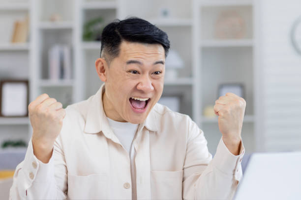 istock Excited man celebrating success at home office 2151071356
