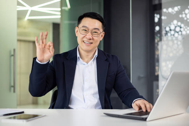 istock Professional Asian businessman waving hello during video call 2151072720