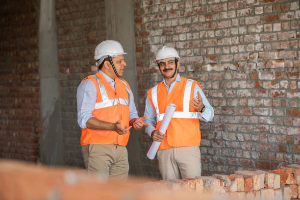 istock Male architects discussing construction details at site 2151073167
