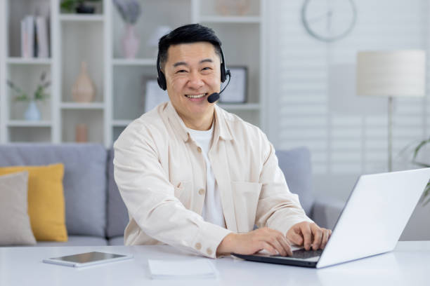 istock Smiling Asian man with headset working from home office 2151074113