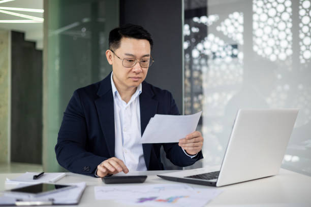 istock Professional Asian businessman reviewing documents in office 2151074205