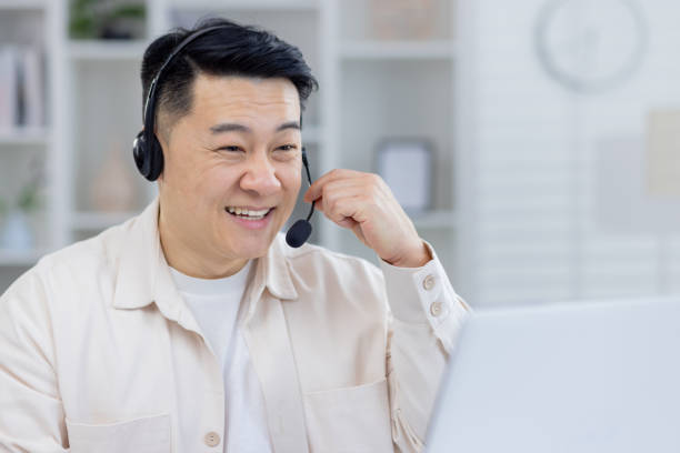 istock Smiling Asian man with headset working in home office 2151074447