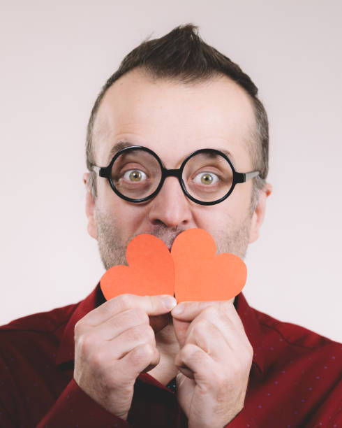 Adult positive man holding red hearts. Male in love. Romance feelings valentines day concept