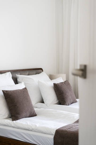 istock Open door in hotel room with comfortable double bed 2151074995