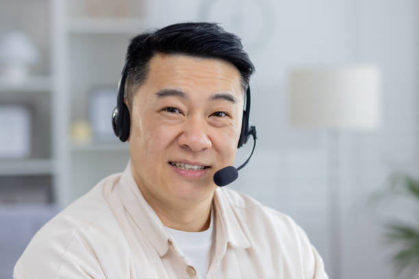 istock Smiling Asian man with headset working from home office 2151075044