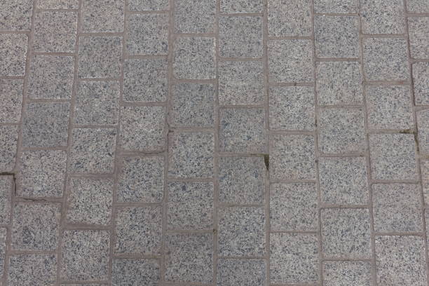 istock Background - pavement made of gray unpolished granite stone blacks 2151075183