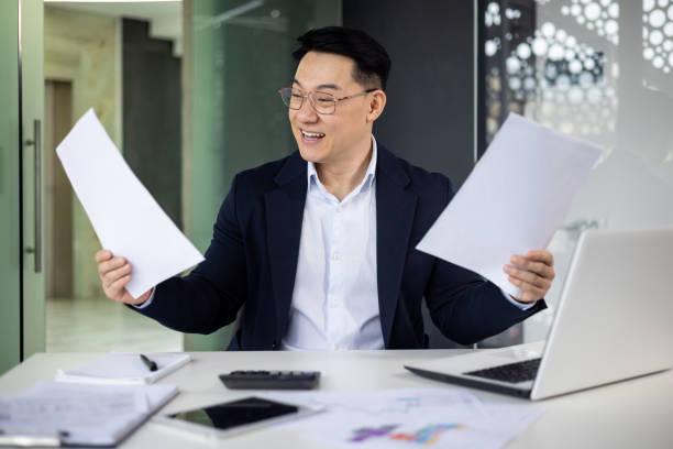 istock Happy businessman reviewing documents at his office desk 2151076938