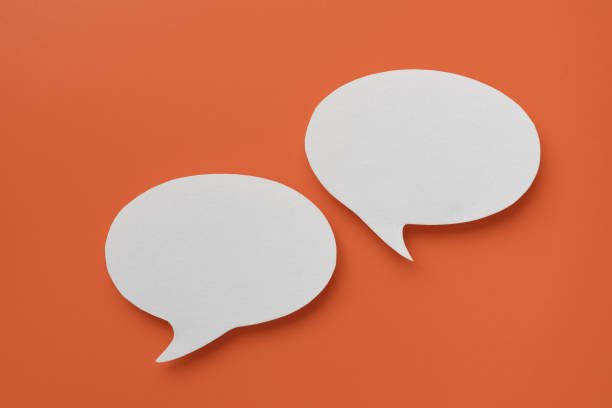istock Conceptual image about communication and social media, customer feedback, couple real blank white speech bubble paper cut on orange color background 2151077035