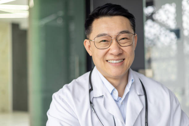 istock Confident Asian mature doctor smiling in clinic setting 2151079127