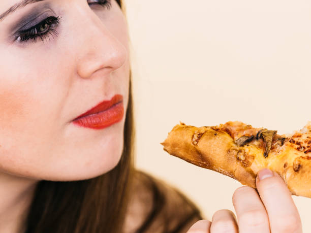 istock Woman eating hot pizza slice 2151080423