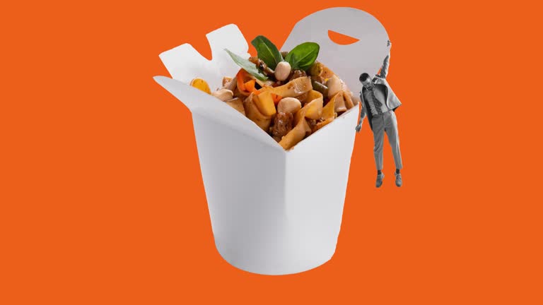 Stop motion. Animation. Man holding on box with Chinese noodles, WOK isolated over orange background. Delicious
