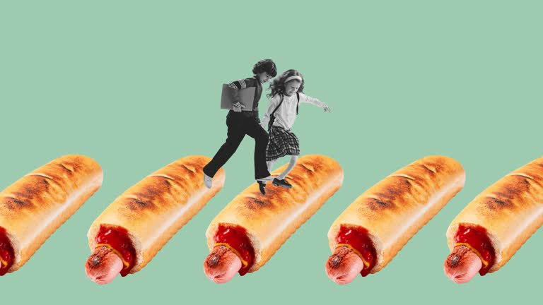 Stop motion. Animation. Cheerful children, boy and girl, pupils jumping over hot-dog isolated over blue background