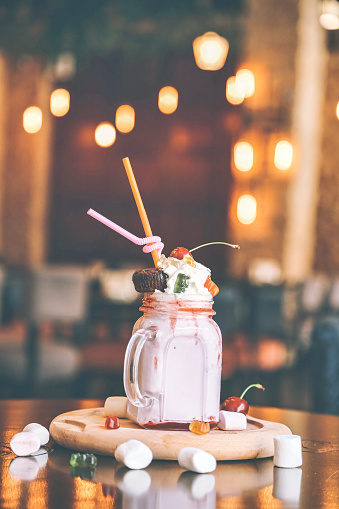 A mason jar filled to the brim with fluffy whipped cream and an assortment of colorful candies.