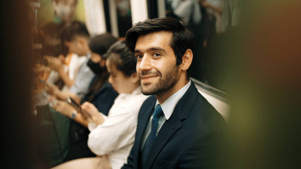 istock Smiling business man looking at mobile phone while sitting in train. Exultant. 2151081264