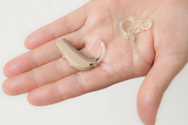 istock senior person holding hearing aid closeup 2151081706
