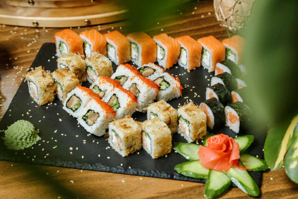 Black Plate With Sushi and Cucumbers