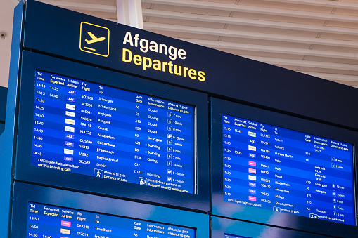 Copenhagen, Denmark - April 7, 2024: Flight boarding information screens at Copenhagen airport.