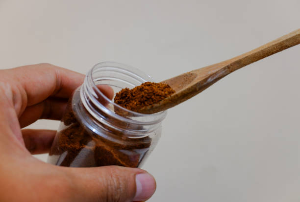 istock A hands holding a jar of coffee and a spoon, with cream background 2151084551