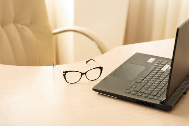 Glasses and laptop on the table.