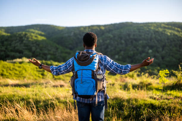 Hiker with arms raised enjoys in nature