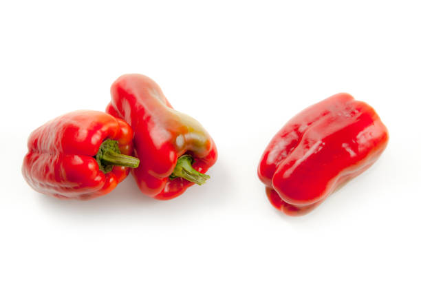 Three red paprikas on wite background close-up