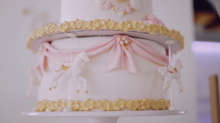 Elegant carousel cake with pink drapes and golden trim, perfect for parties