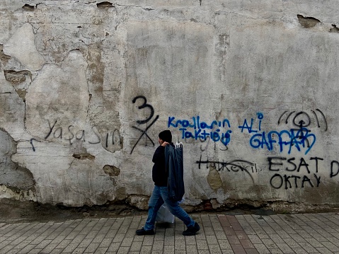 Man walks along the wall, Bursa, Turkey - November 20 2023
