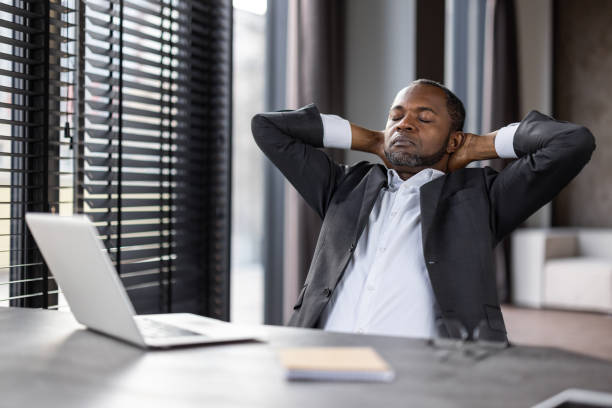 istock Businessman relaxing in modern office with hands behind head 2151088202