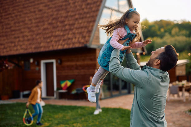 Playful father and daughter having fun in the backyard,