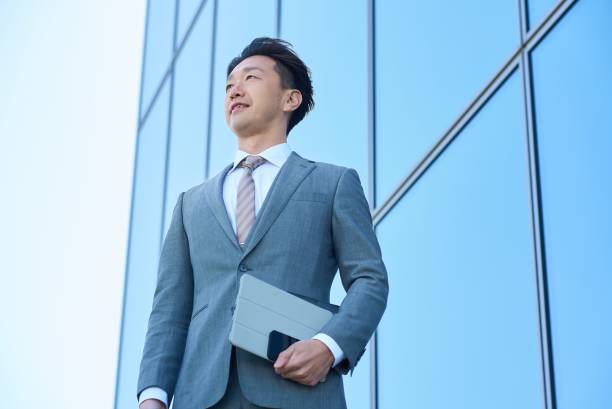 istock Businessman in a suit looking up at the sky 2151090184