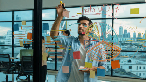 istock Businessman uses sticky notes at glass wall to brainstorming idea. Tracery 2151090819