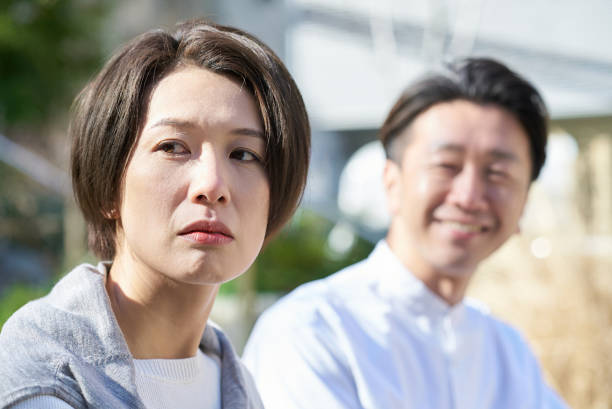A woman looking unhappy next to a man