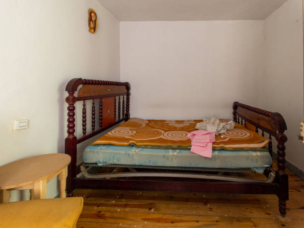 istock A bed with a pink towel on it and a wooden headboard 2151099046