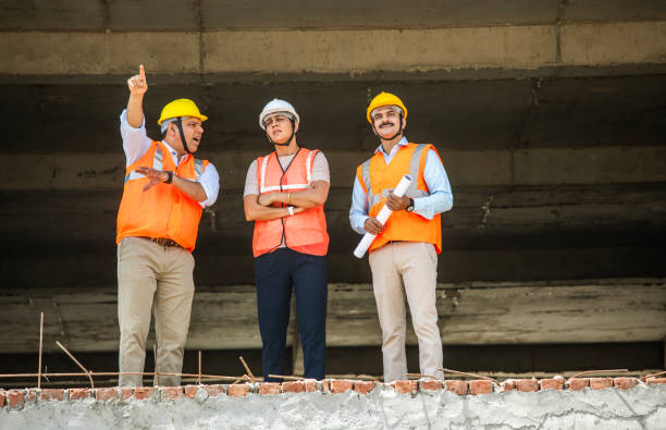 istock Coworkers discussing building plan at construction site 2151099358