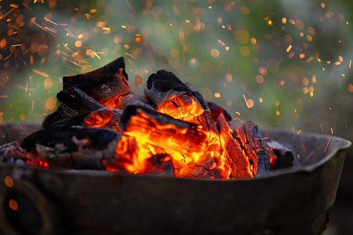 Burning coals in barbecue with flames.