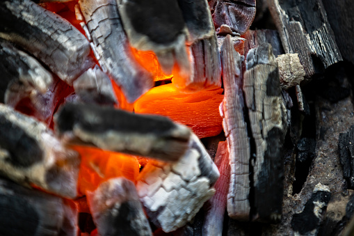 Charcoal burning under a grill at a barbecue.