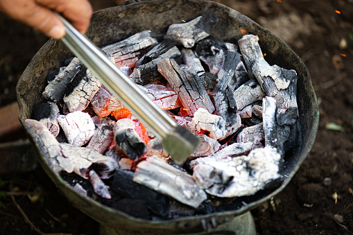 Charcoal burning under a grill at a barbecue.