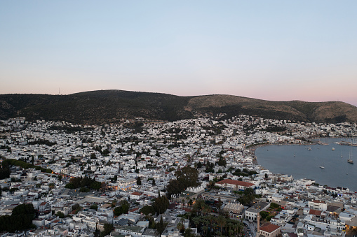 Bodrum city aerial shot. Aegean sea, traditional white houses, flowers, marina, sailing boats, yachts in Bodrum town Turkey.