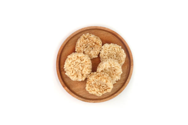Rengginang or Rangginang, Traditional Indonesian Rice Crackers, made from rice or sticky rice. Savory and crunchy. Served on a wooden plate and isolated on a white background.