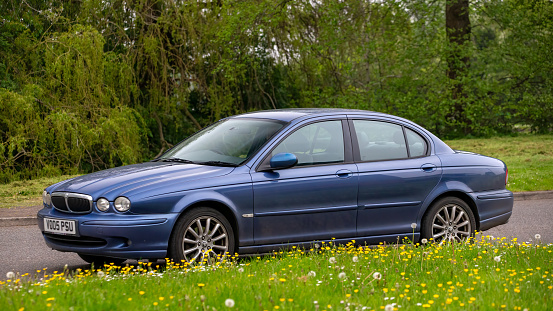 Milton Keynes,UK - May 2nd 2024:2005 blue Jaguar x type diesel  car driving on a British road