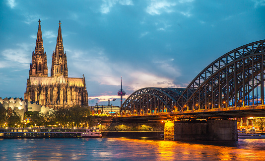 The Cologne Cathedral and Hohenzollern Bridge at night, cityscape, golden hour, travel