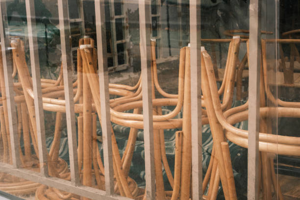 Close-up on a group of stools stacked behind a plastic curtain.