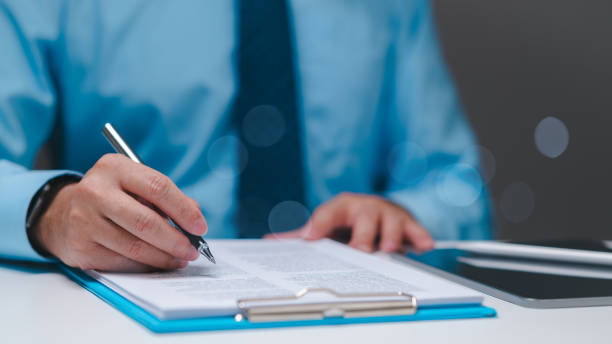 istock Manager swiftly navigates banking paperwork, signing loan agreements and approving applications, ensuring success in facilitating financial transactions and meeting business objectives. 2151104575