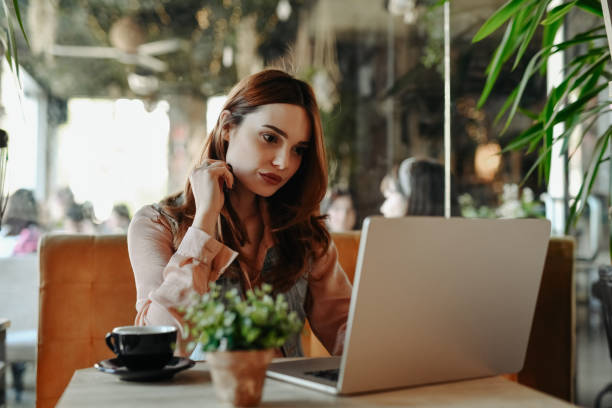 istock Beautiful Female User Interface Designer Working On Laptop With Afternoon Coffee In Bar 2151105562